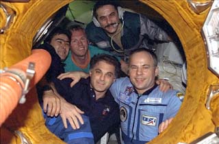 Mir-24 and STS-89 crewmembers appear in the Mir Space Station Docking Module (DM) airlock before the undocking of Mir and the Orbiter Endeavour.